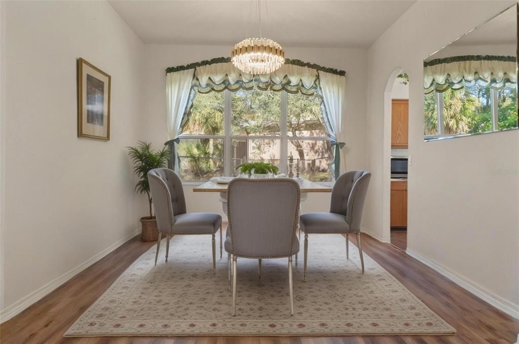 11405 Warm Wind Way Weeki Wachee, FL 34613 - Photo 26 of 46 a view of a dining room with furniture a rug and wooden floor