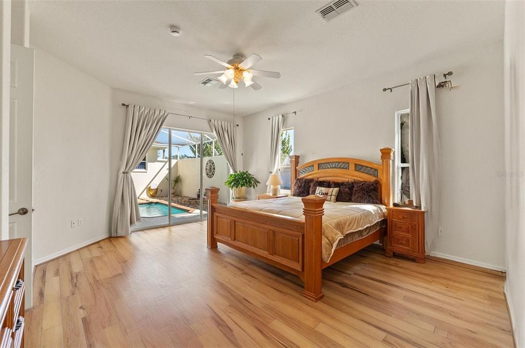 11405 Warm Wind Way Weeki Wachee, FL 34613 - Photo 27 of 46 a bedroom with a bed and a chandelier