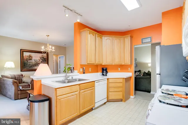 a living room with furniture kitchen view and a chandelier
