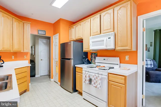 a kitchen with stainless steel appliances granite countertop sink stove and refrigerator