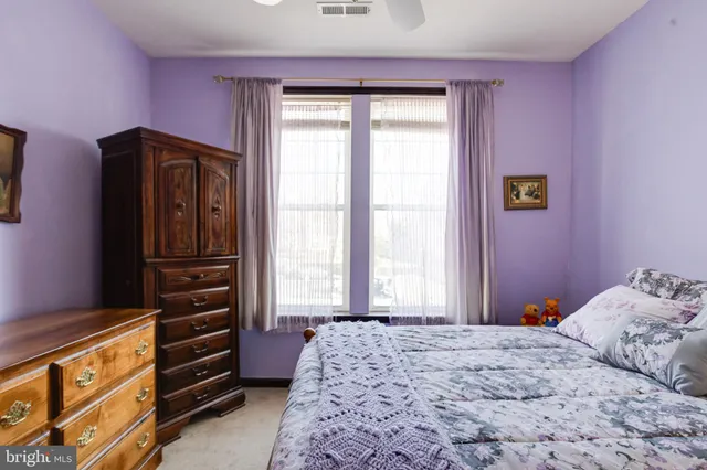 a bedroom with a bed dresser and window
