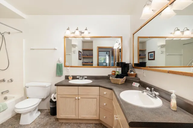 a bathroom with a sink vanity mirror and toilet