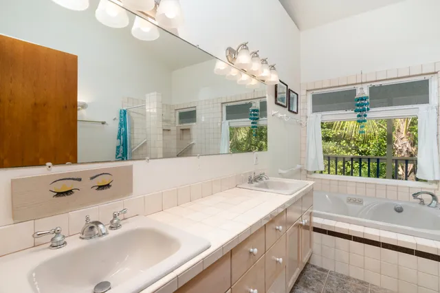 a bathroom with a tub a sink and a large mirror