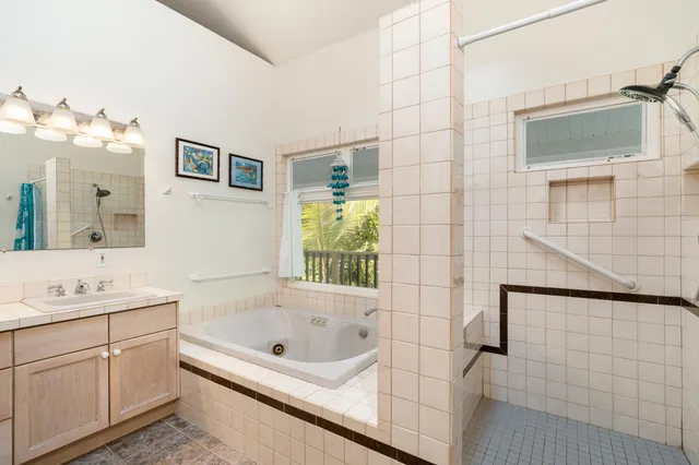 a bathroom with a bathtub sink and mirror
