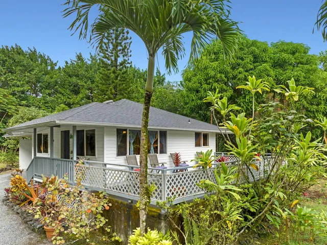 a front view of a house with a garden