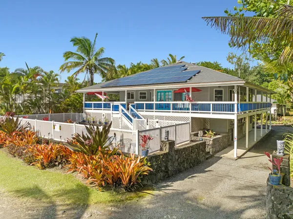 a view of a house with a small yard and swimming pool