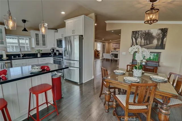 a kitchen with a dining table chairs and refrigerator