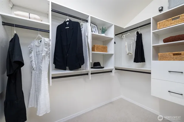a view of walk in closet with clothes and shoes