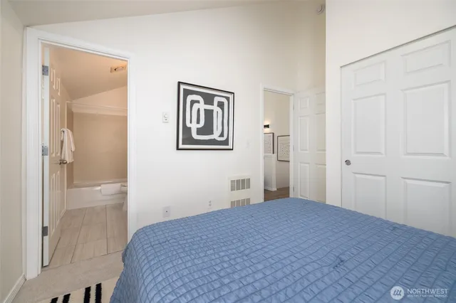 a bedroom with a bed and a painting on the wall