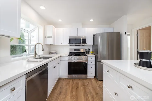 a kitchen with stainless steel appliances a refrigerator stove and sink