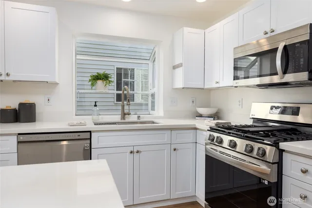 a kitchen with white cabinets and appliances