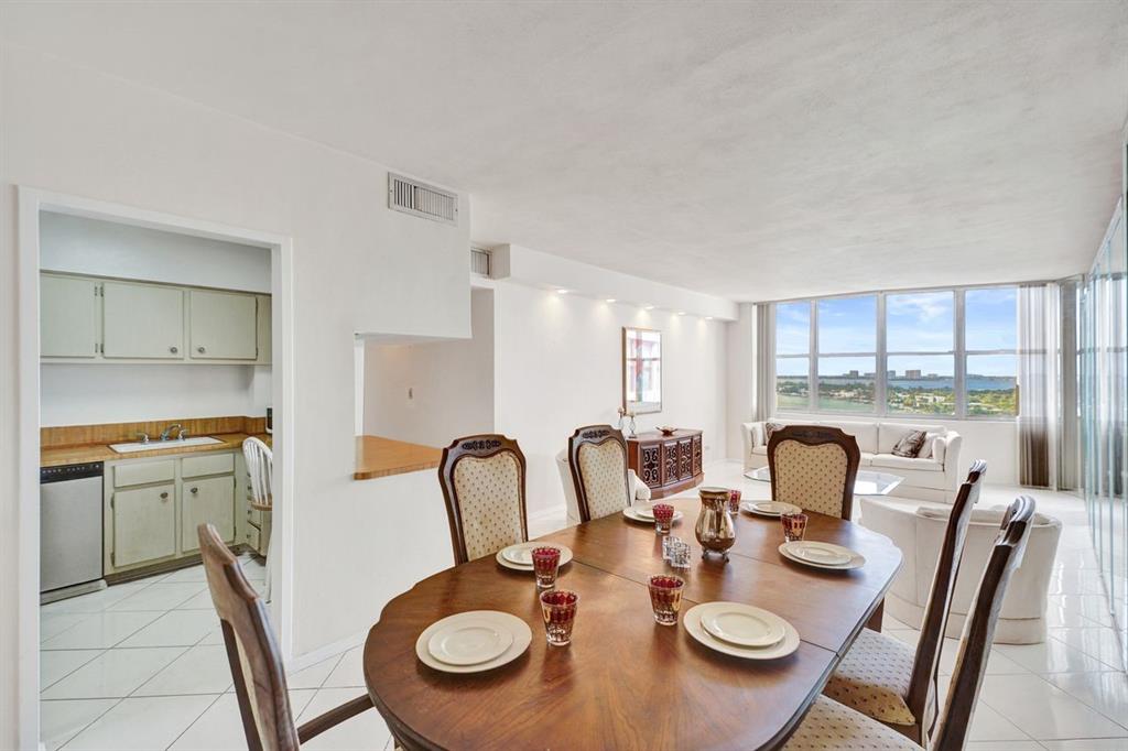 7441 Wayne Avenue, Unit 10C Miami Beach, FL 33141 - Photo 20 of 86 a dining room with furniture a kitchen and chandelier