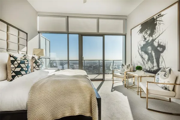 a bedroom with a bed and a large window with the outer view