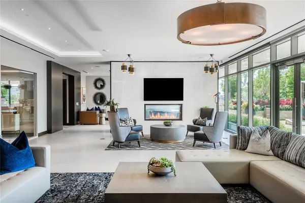 a living room with furniture a flat screen tv and a large window