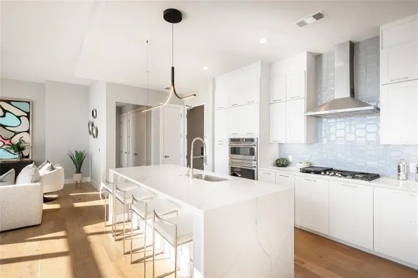 a kitchen with stainless steel appliances kitchen island granite countertop a sink a stove and a refrigerator