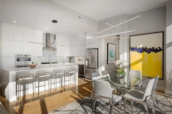 a kitchen with stainless steel appliances granite countertop a table and chairs in it