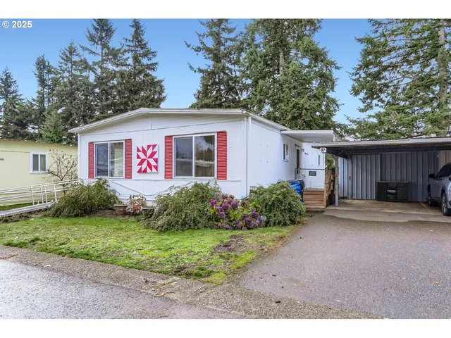a view of a white house with a yard and potted plants