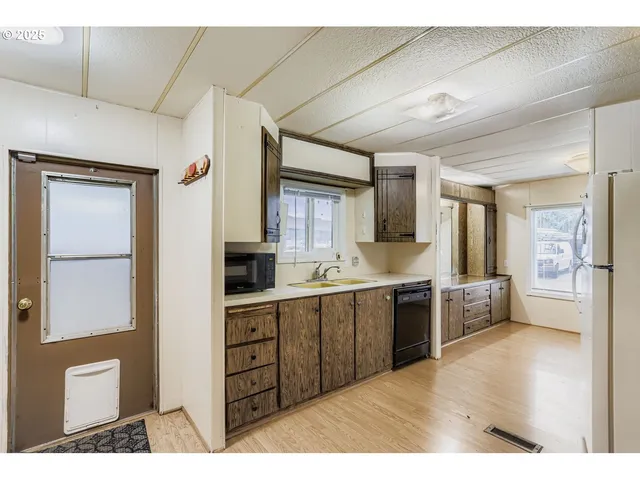 a open kitchen with cabinets and wooden floor