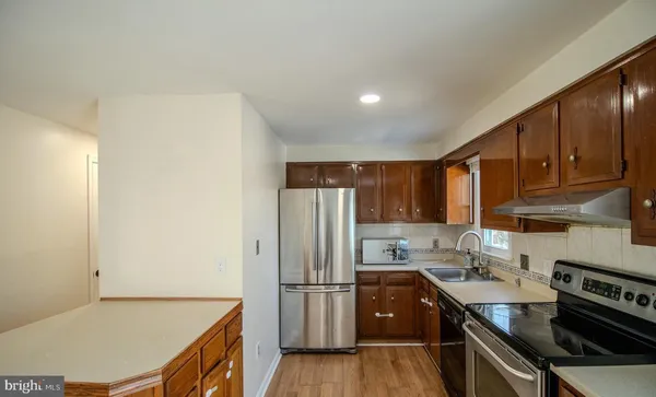 a kitchen with a refrigerator a stove a sink and cabinets