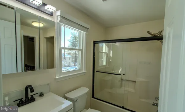 a bathroom with a shower sink and mirror