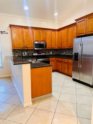 a kitchen with stainless steel appliances granite countertop a stove a sink and a microwave