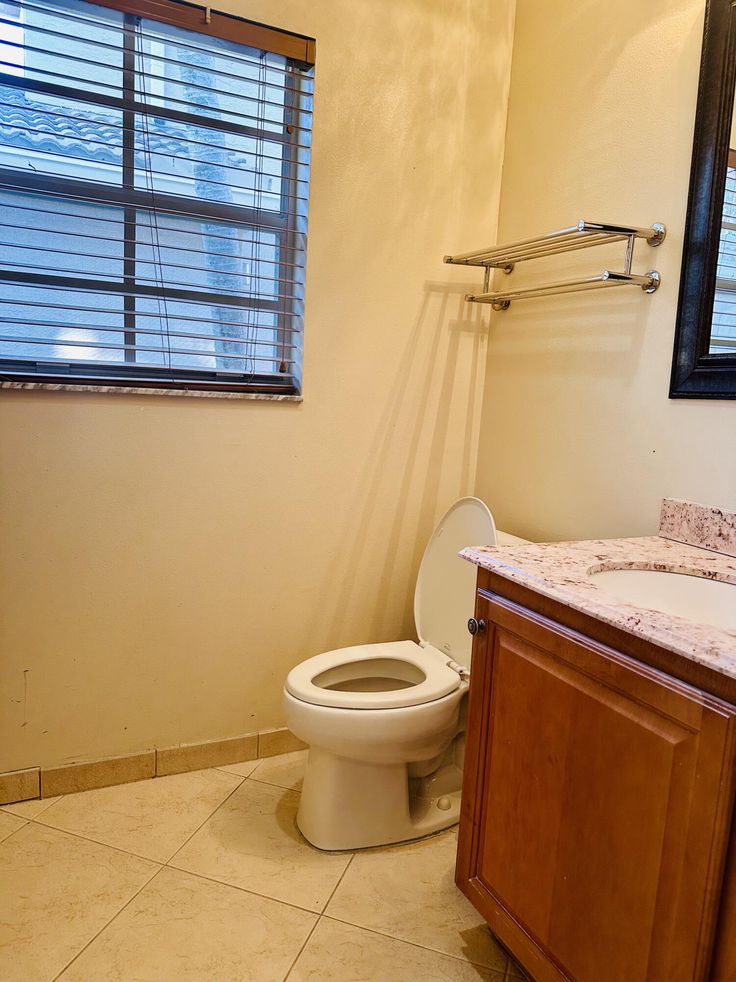5200 Rising Comet Lane Greenacres, FL 33463 - Photo 28 of 50 a bathroom with a granite countertop toilet and a sink