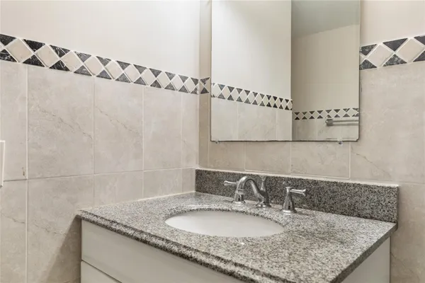 a bathroom with a granite countertop sink and a mirror