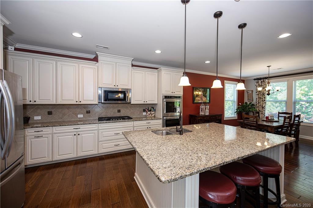 1452 Cilantro Court Tega Cay, SC 29708 - Photo 14 of 48 a kitchen with stainless steel appliances granite countertop counter space a sink cabinets and wooden floor