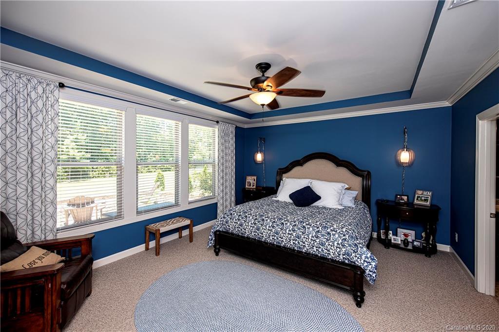 1452 Cilantro Court Tega Cay, SC 29708 - Photo 19 of 48 a bedroom with a bed and a chandelier
