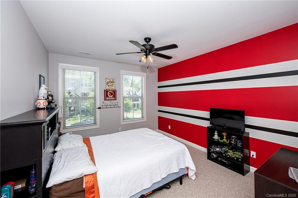 1452 Cilantro Court Tega Cay, SC 29708 - Photo 30 of 48 a bedroom with a bed and a chandelier