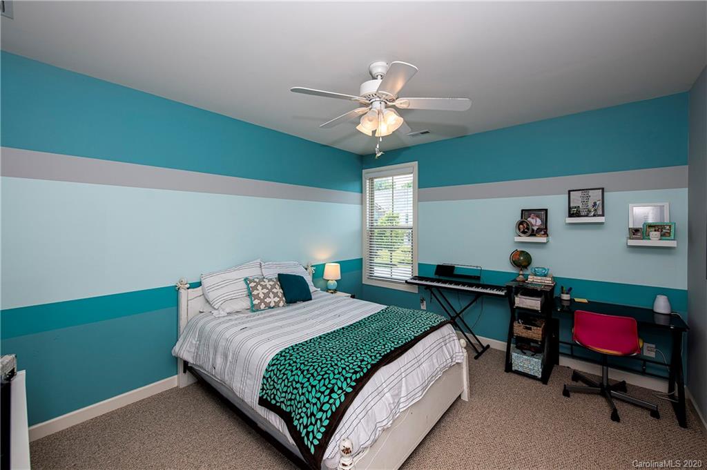 1452 Cilantro Court Tega Cay, SC 29708 - Photo 33 of 48 a bedroom with a bed and a chandelier