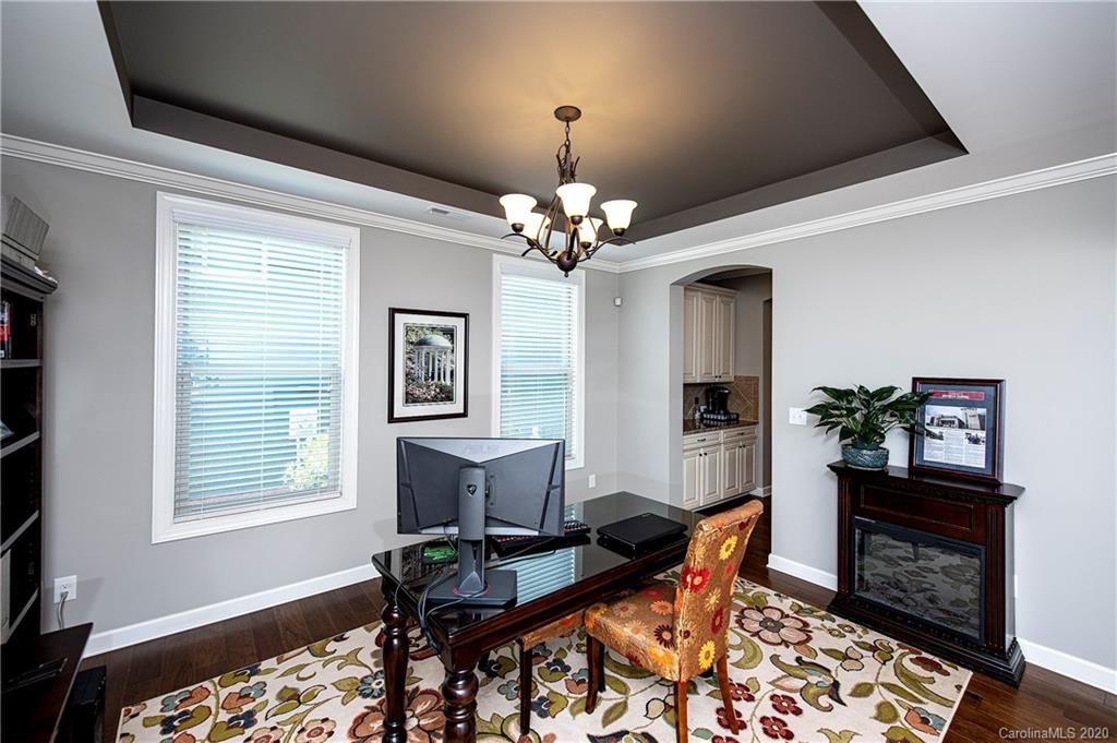 1452 Cilantro Court Tega Cay, SC 29708 - Photo 8 of 48 a dining room with wooden floor a chandelier a wooden table and chairs