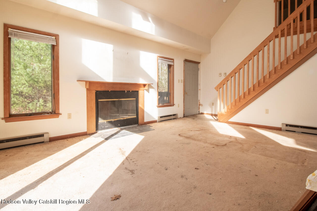 140 Stillerberg Strada Kerhonkson, NY 12446 - Photo 11 of 34 a view of an empty room with wooden floor fireplace and a window
