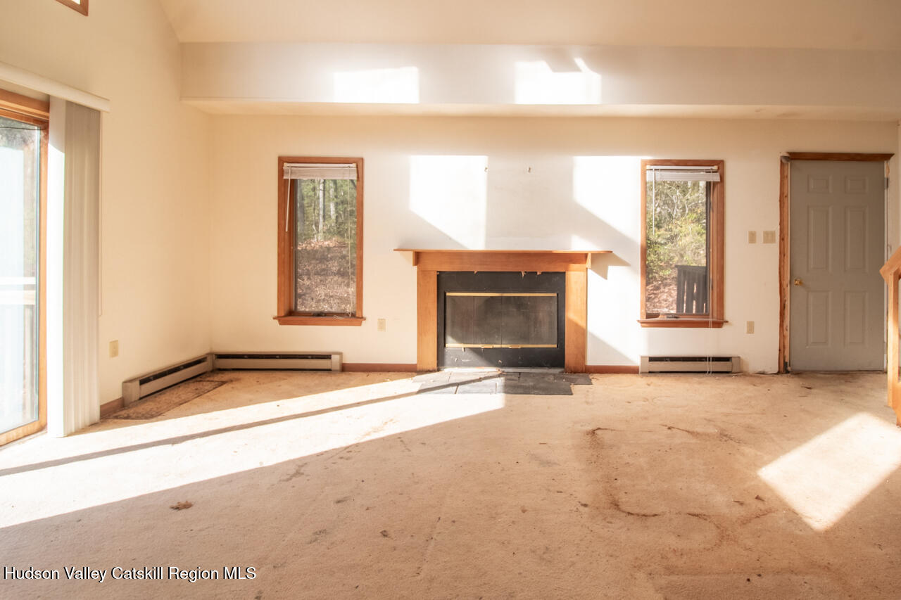140 Stillerberg Strada Kerhonkson, NY 12446 - Photo 12 of 34 an empty room with windows and fireplace