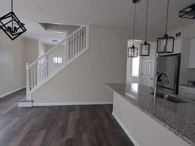 a kitchen with granite countertop a sink a stove and cabinets