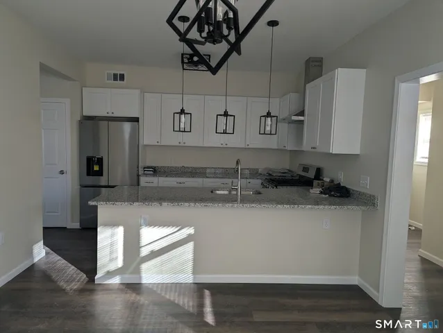 a kitchen with granite countertop a sink stove and cabinets