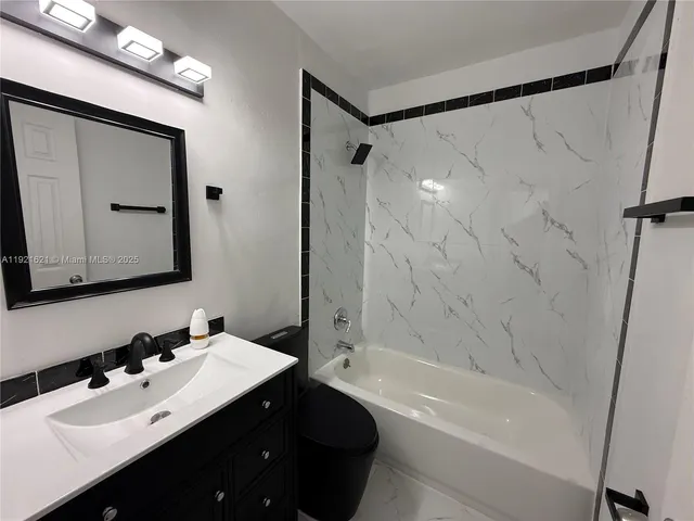 a bathroom with a bathtub shower sink vanity and mirror