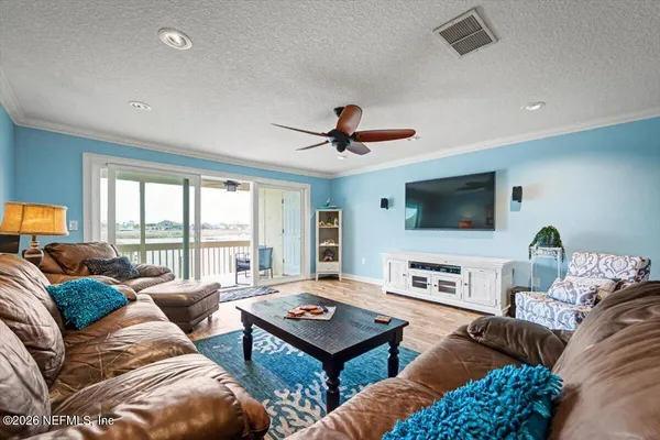a living room with furniture flat screen tv and a large window