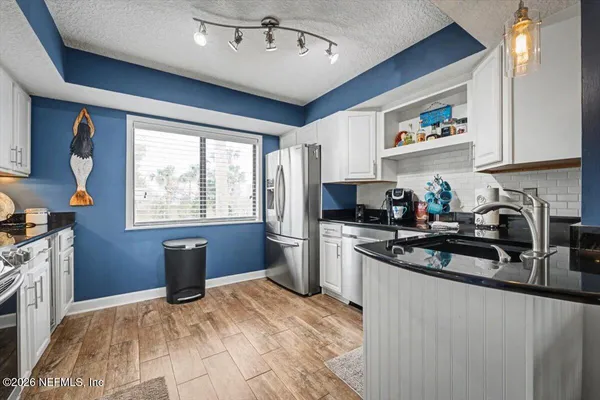 a kitchen with granite countertop a sink stainless steel appliances and cabinets