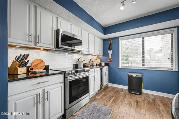 a kitchen with stainless steel appliances a refrigerator sink and microwave