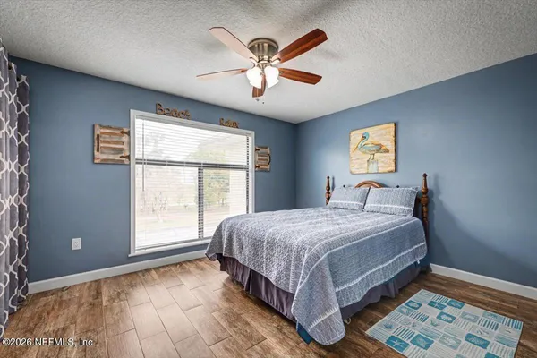 a bed sitting in a spacious bedroom next to a window