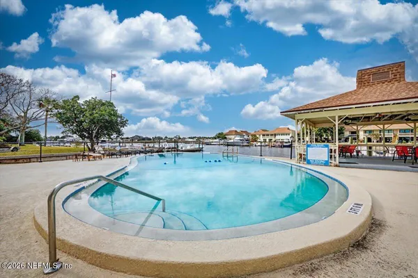 a view of a swimming pool with a table and chairs in the patio