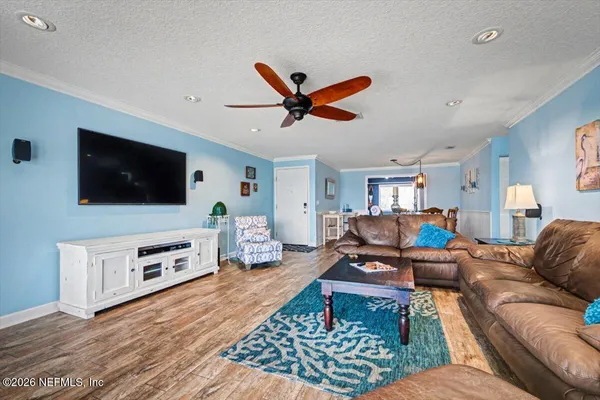 a living room with furniture flat screen tv and a large window