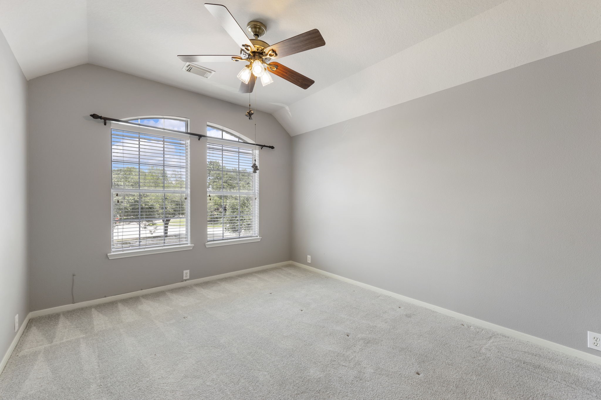 2907 Stemwood Drive Spring, TX 77388 - Photo 24 of 33 Bright secondary bedroom featuring soft natural light, plush carpeting, and elevated windows that add architectural character. A versatile space ideal for guests, a home office, or additional living needs.