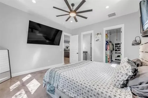 a bedroom with a large bed and a flat screen tv