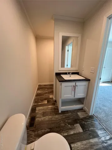 a bathroom with a sink mirror vanity and toilet