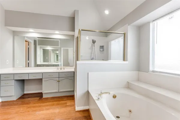 a bathroom with a bathtub a mirror a sinks and a shower
