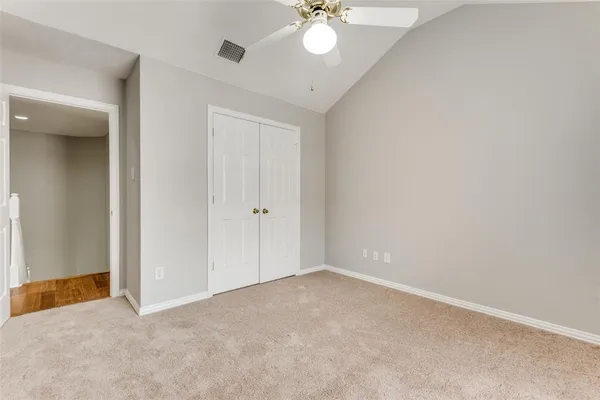 a view of an empty room with a chandelier fan