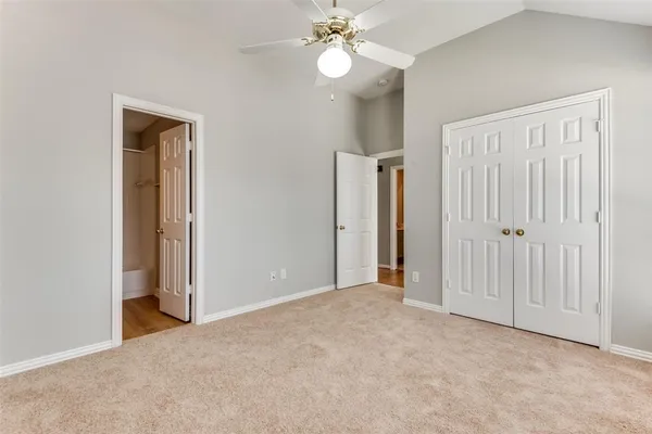 an empty room with closet and a chandelier fan