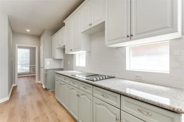 a kitchen with granite countertop white cabinets and white appliances